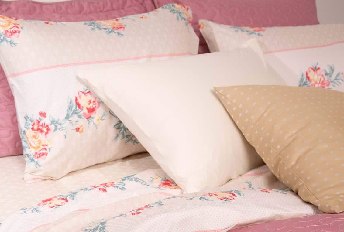 Travesseiros com fronhas macias e estampadas pela cama